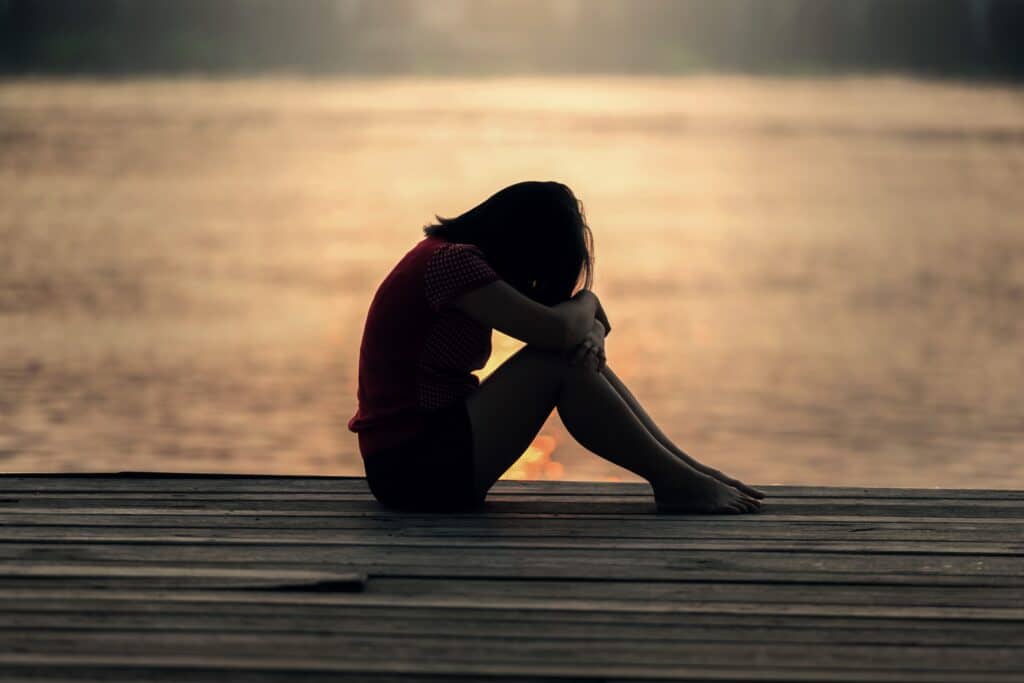 silouette of girl on pier at sunset