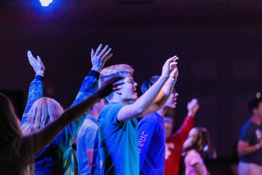 teens raising hand in a worship service