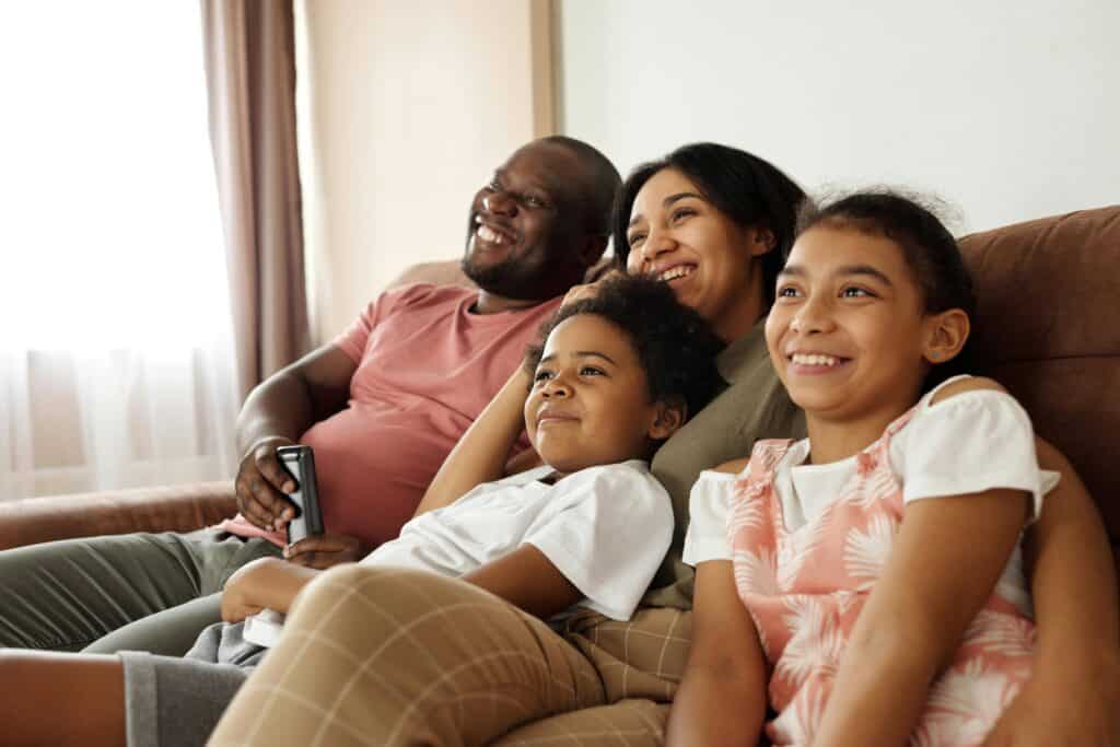 family mom dad kids looking out TV remote
