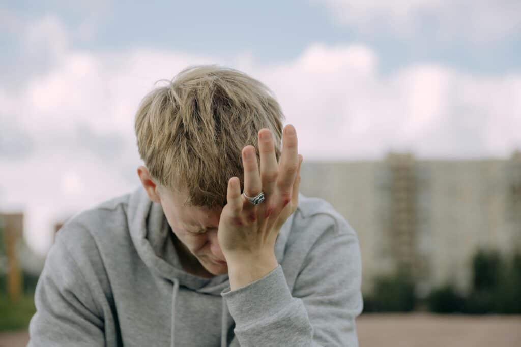 young man class ring head in palm upset