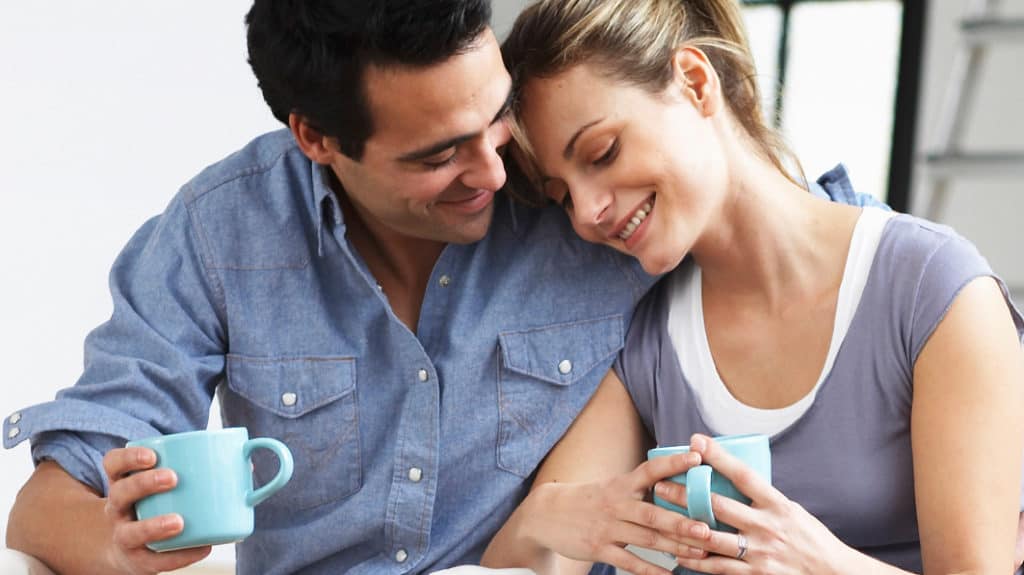 Married couple embracing while sitting inside