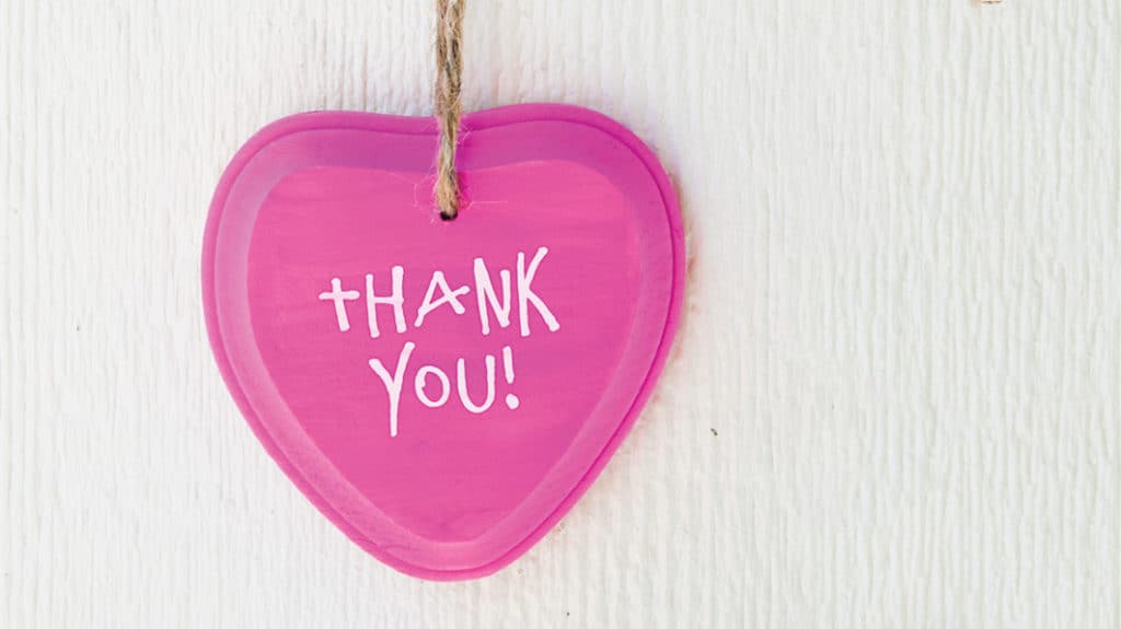Close up of a pink heart with the phrase "thank you!"