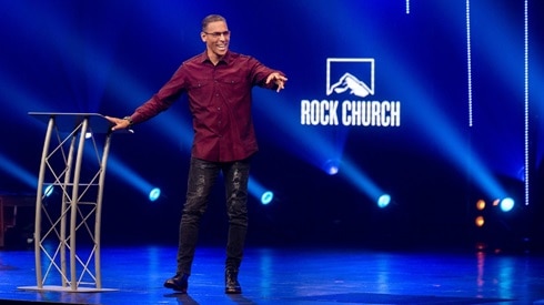 pastor miles mcpherson standing near his pulpit at rock church preaching a sermon