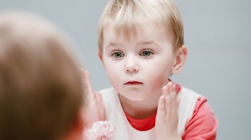 boy looking at himself in the mirror