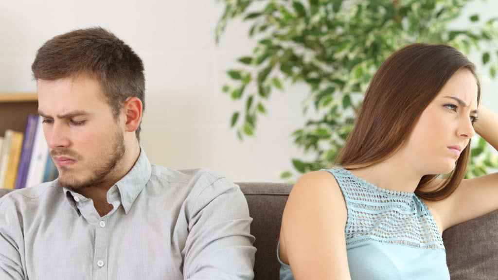 A man and woman sit silently after arguing