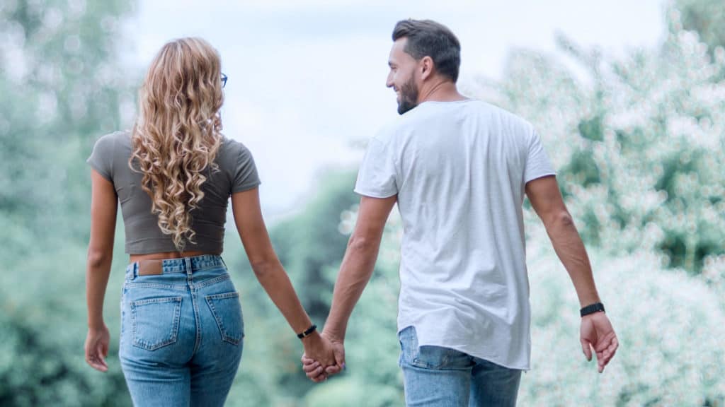 A Man and woman walk together down a long path