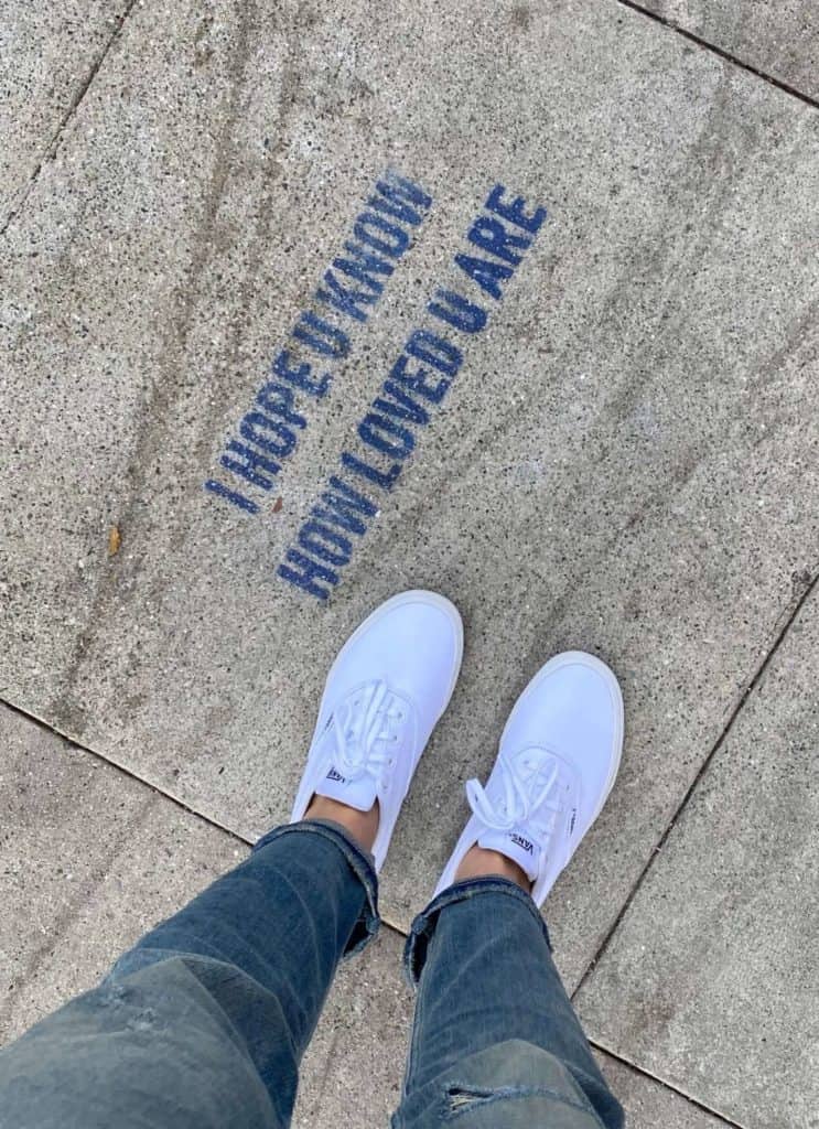 women's feet looking at sign saying I hope u know how loved u are