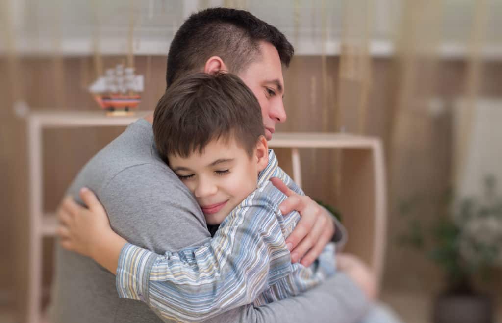 photo of a father and son embracing in forgiveness.