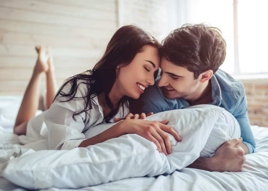 happy-husband-and-wife-lying-in-bed