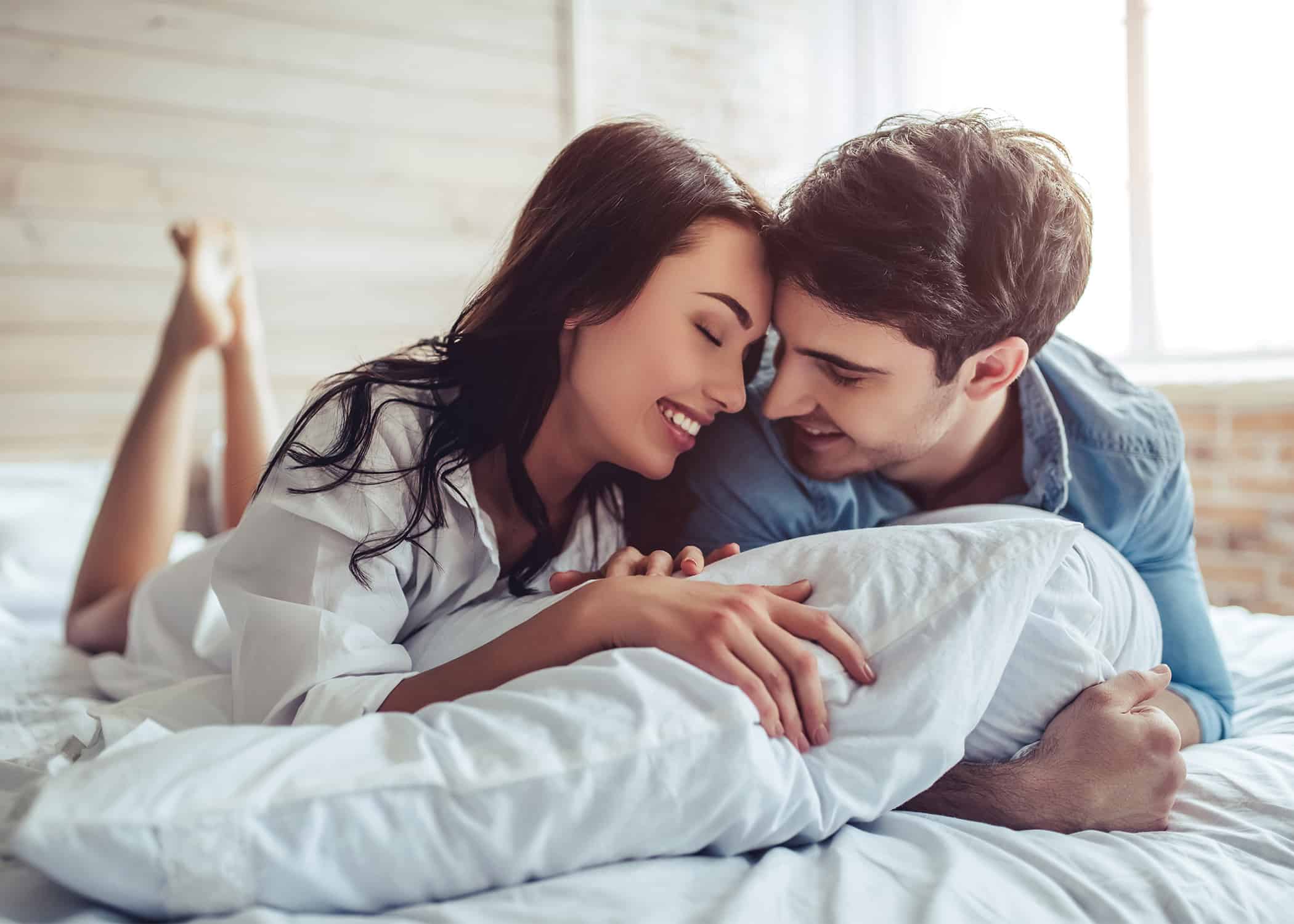 happy-husband-and-wife-lying-in-bed