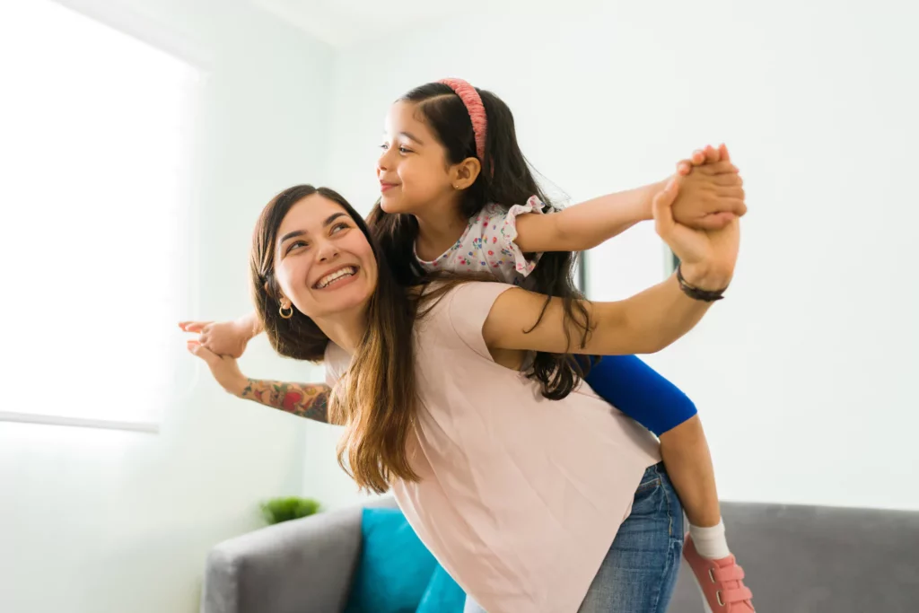 Mother smiling at daughter on her shoulders