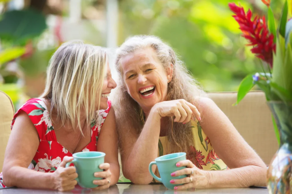 Two moms laughing together over coffee