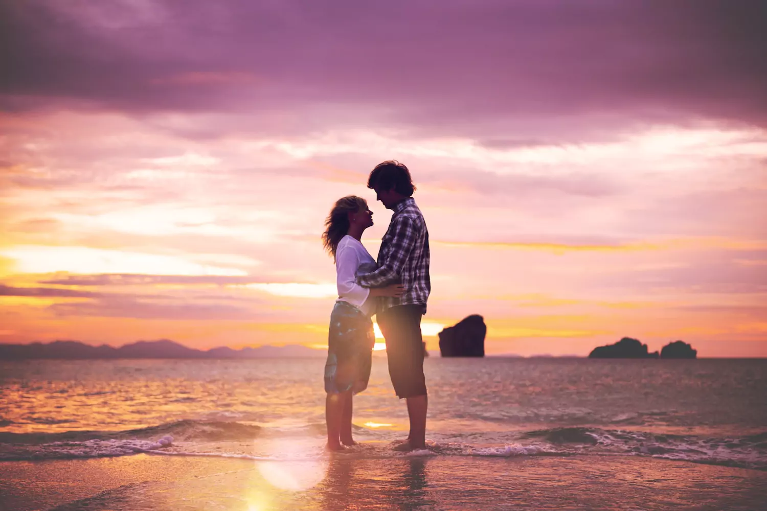 A couple embracing at sunset on the beach, symbolizing true love for your spouse through emotional connection and romantic devotion.