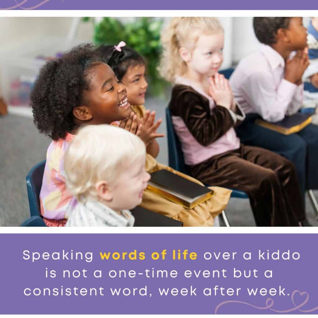 Foster care and the church — children sit joyfully in a classroom setting with Bibles on their laps, smiling and clapping as part of a church community’s consistent care